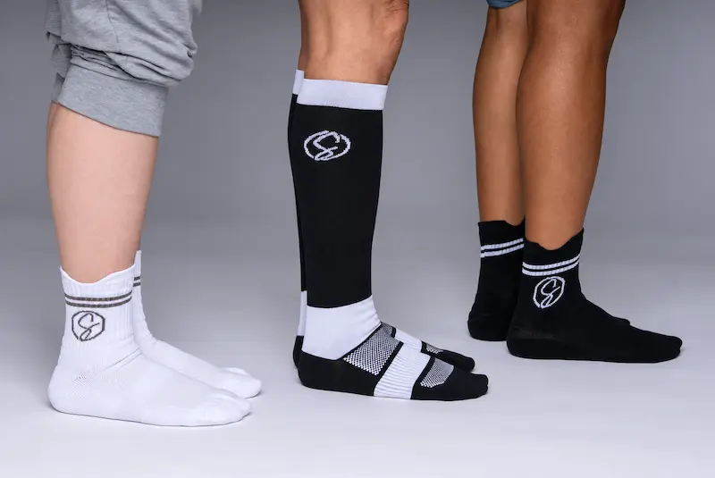 Side profile lineup of three models wearing Stridely crew and knee-high socks